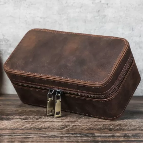 Closed Roroos brown leather travel jewellery box with secure strap closure — compact enough for carry-on luggage